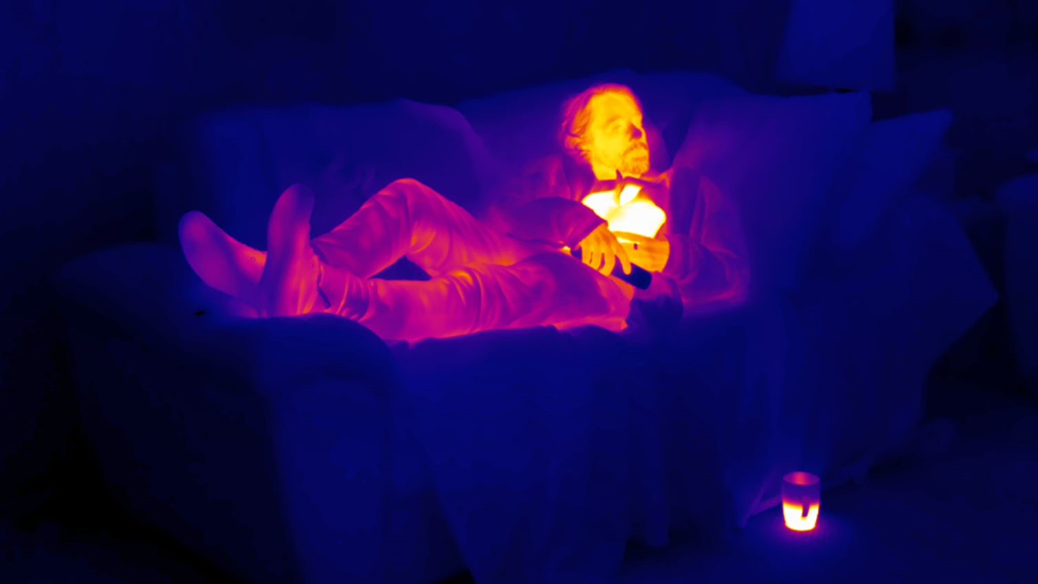 Image of a man lying on sofa showing thermo imagery of heat 