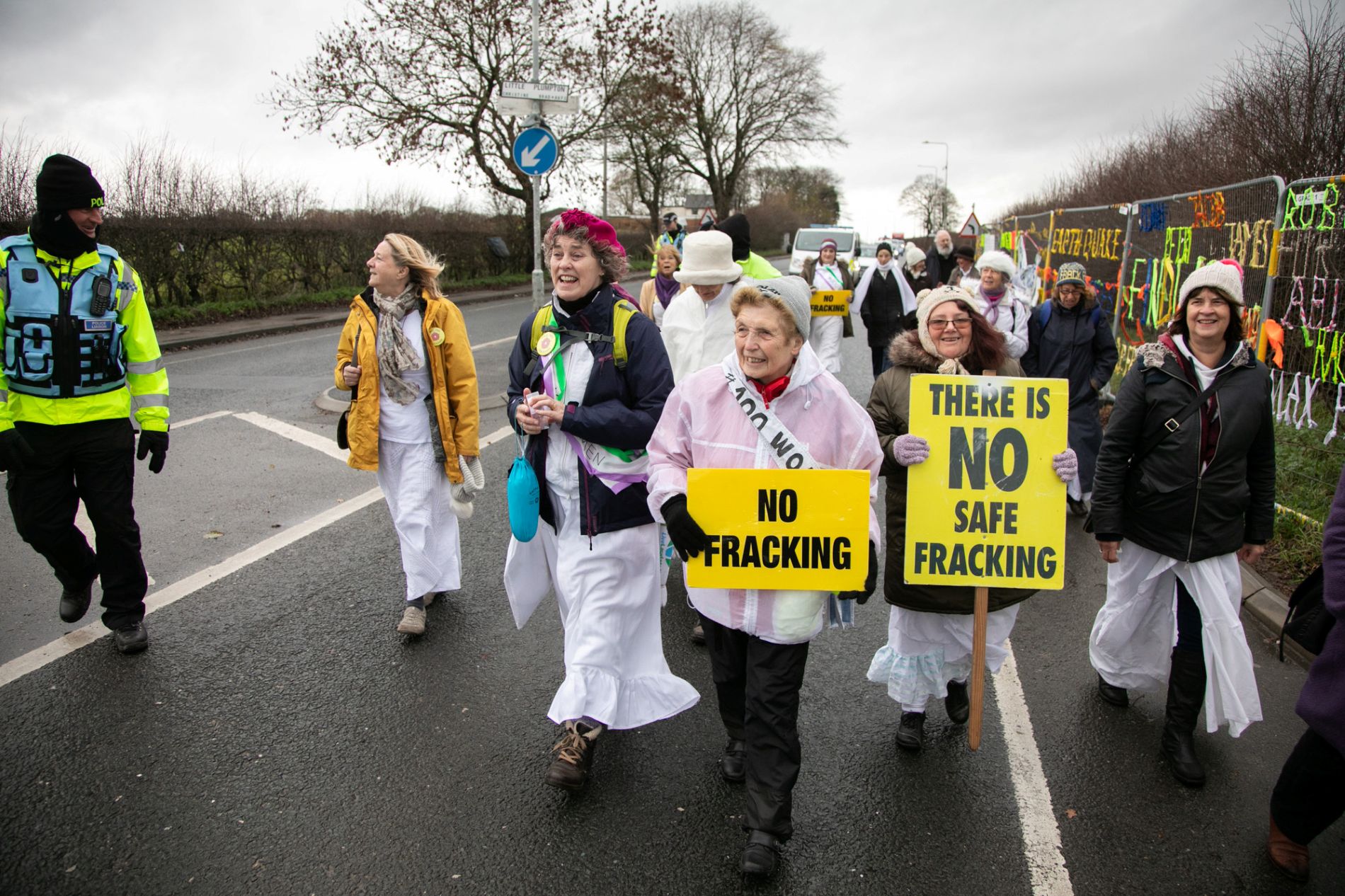 Women march in a road holding anti-fracking billboards COPYRIGHT Kristian Buus